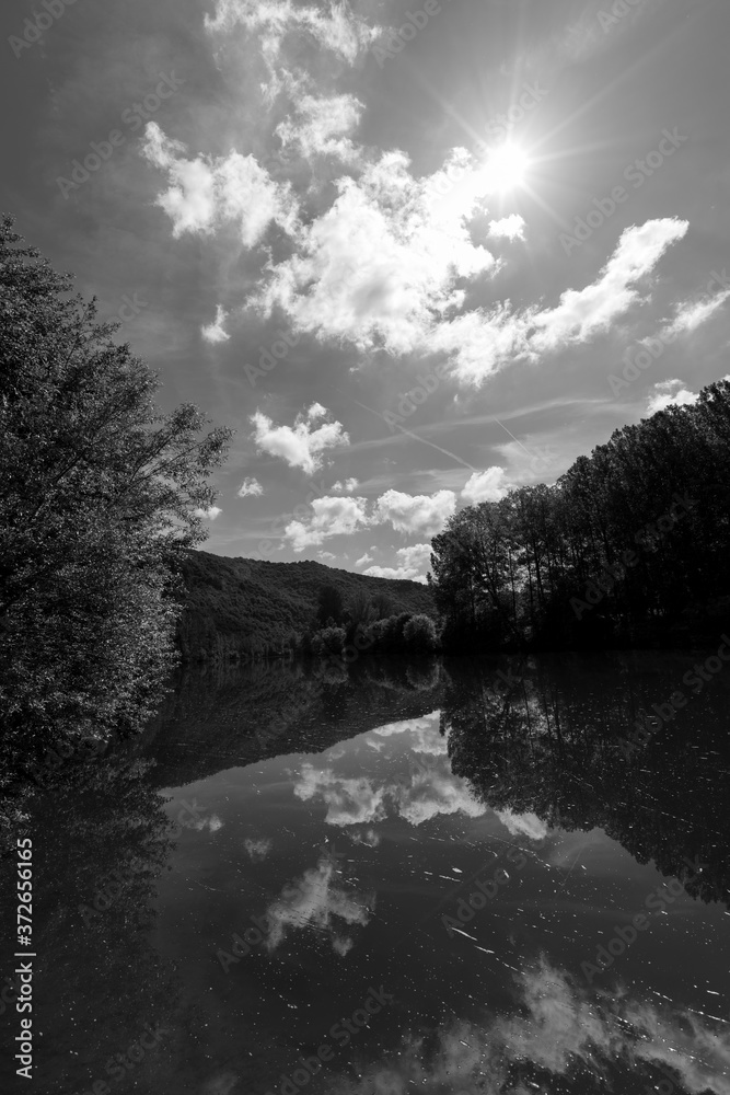Fototapeta premium River Tarn in Ambialet French Country Side Photo in Bright Tones with Gorgeous Trees and Flowing Background Wallpaper Black and White Monochrome