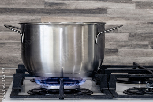 metal pan dishes are heated on the gas stove gas burner flame and hot food in the kitchen