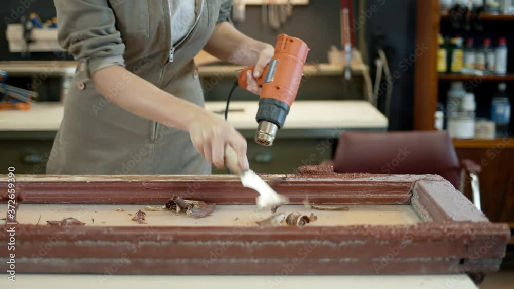 Restoration of wooden doors, window. A working female carpenter