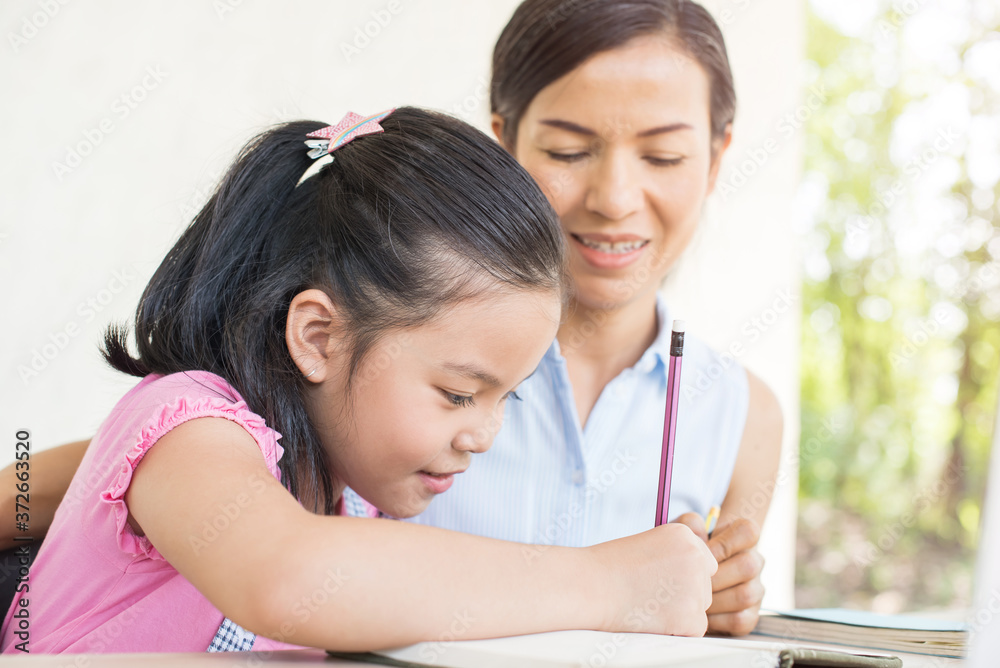 asia girl student online learning study online video call teacher. social distance during quarantine, self-isolation, online education concept, homeschool, cute girl with mother doing homework at home asia girl student online learning study online video call teacher. social distance during quarantine, self-isolation, online education concept, homeschool, cute girl with mother doing homework at home