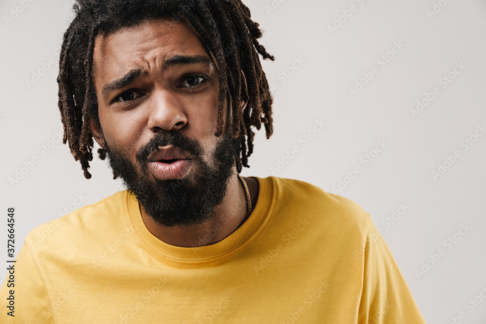 Confused negative african guy posing isolated