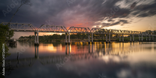 Sunset over a rail bridge crossing over the Burnett River, Bundaberg, Queensland photo