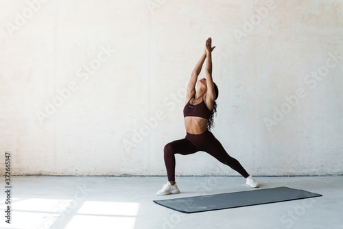Portrait of young african american woman doing workout on mat in room