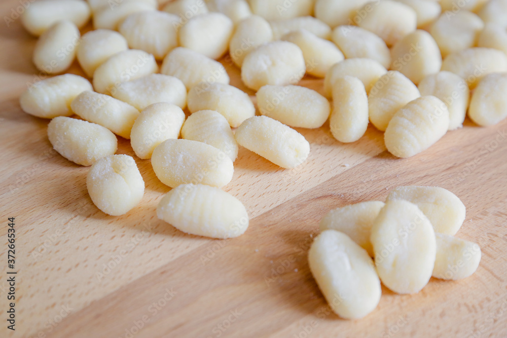 Gnocchi, typical italian pasta, on wooden table, natural light