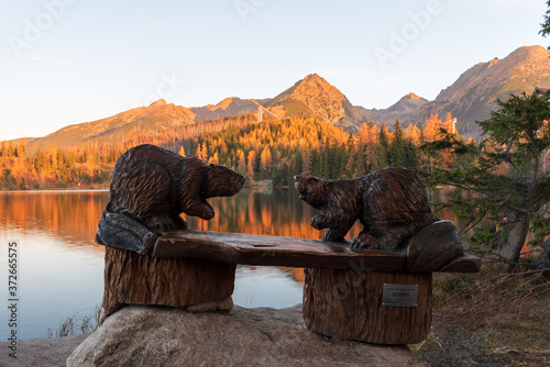 Sculptures of wooden beavers on seat on Strbske pleso in aurumn Vysoke Tatry mountains in Slovakia