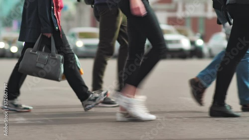 A crowd of pedestrians crosses the street at rush hour. Crowded crosswalk. Scene of urban city life. Anonymous crowd of people on the background of riding mashikhs. Slow motion