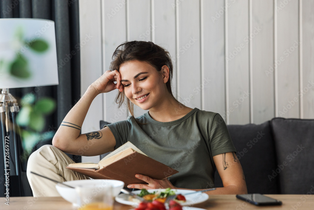 Attractive young woman having tasty healthy breakfast