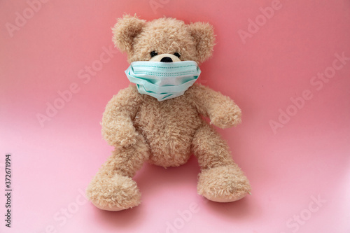 Coronavirus and pollution protection concept. Teddy bear with protective face mask on pink background © Rawf8