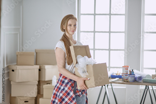 A beautiful single young woman unpacking boxes and moving into a new home © lenetsnikolai