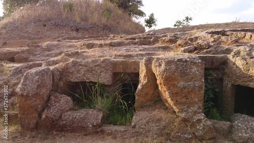 Archeological site, ancient old etruscan necropolis site. Tracking shot of catacombs, sunset, daytime time. Exterior, history concept. Aerial view. Cerveteri, Italy 