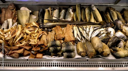 Smoked and salted dried seafood for sale in the showcase. Assortment of fresh fish in a shop window. Fish department in a market