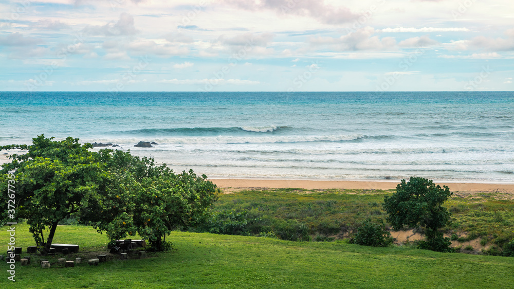 Ocean wave rolling towards sandy beach with green trees of Taiwan island Ocean wave rolling towards sandy beach with green trees of Taiwan island