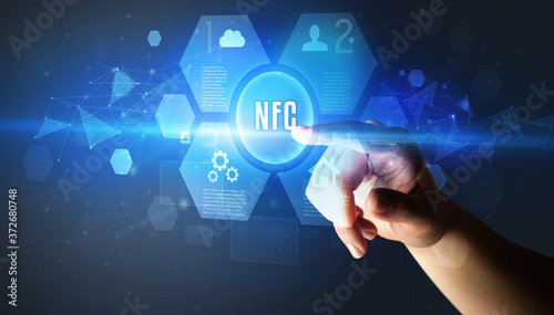 Hand touching NFC inscription, new technology concept