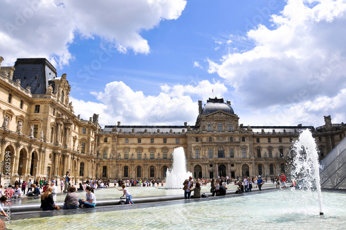 PARIS, FRANCE - JULY 17, 2010: View of pyramid and fountain at courtyard of Louvre Museum. Louvre Museum is one of the largest and most visited museums worldwide.  
