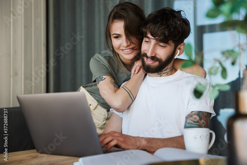 Beautiful young couple using laptop computer