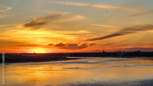 Beautiful orange sunset over big river.