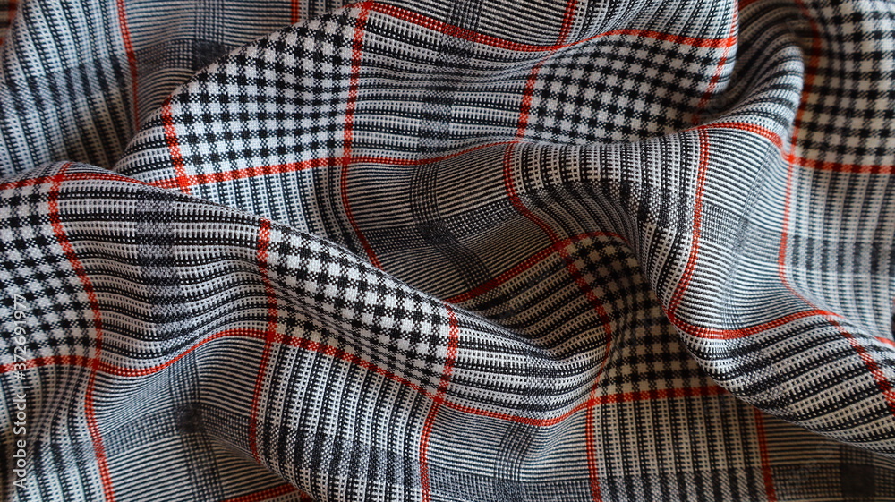 Textile gray plaid fabric with red lines close-up Textile gray plaid fabric with red lines close-up