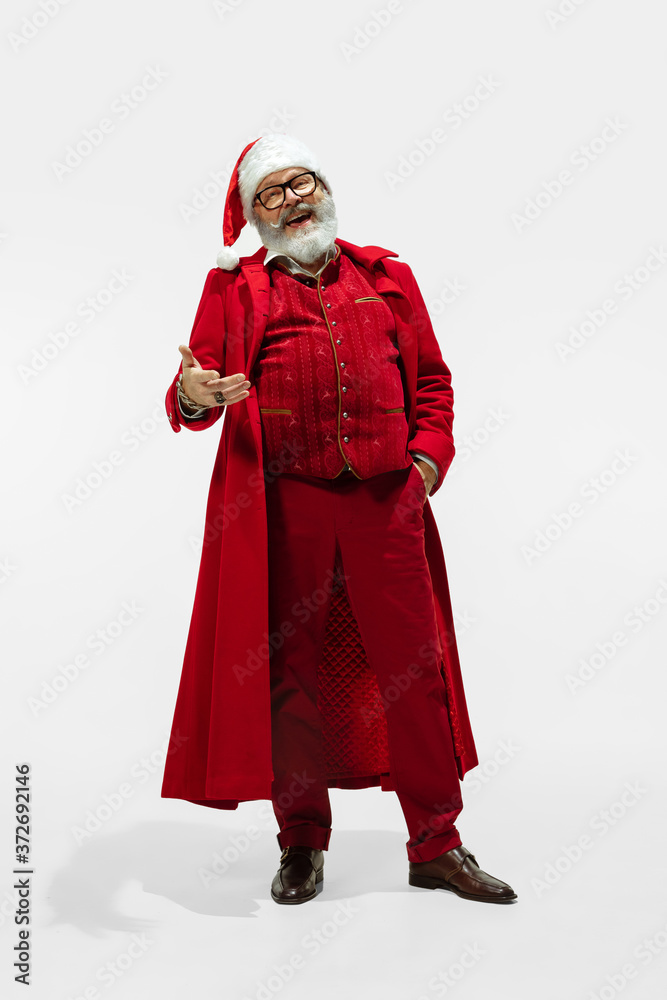 Gesturing. Modern stylish Santa Claus in red fashionable suit isolated on white background. Looks like a rockstar. New Year and Christmas eve, celebration, holidays, winter's mood, fashion.