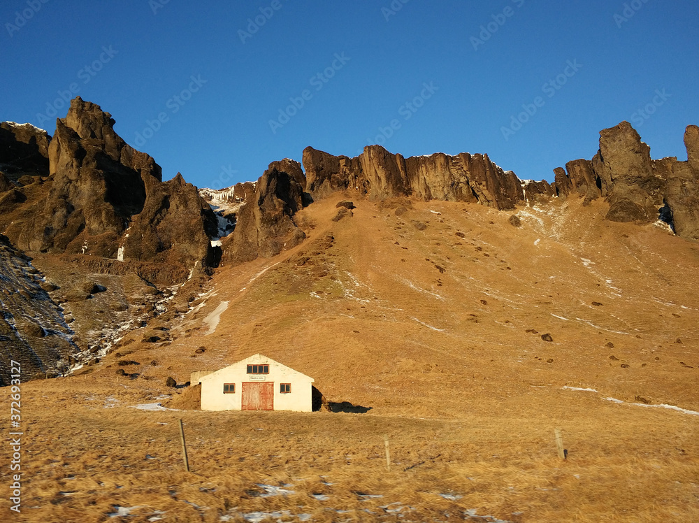 A lonely house at the foot of the mountains in Iceland. Incredible landscapes of nature. Life for a social phobia A lonely house at the foot of the mountains in Iceland. Incredible landscapes of nature. Life for a social phobia