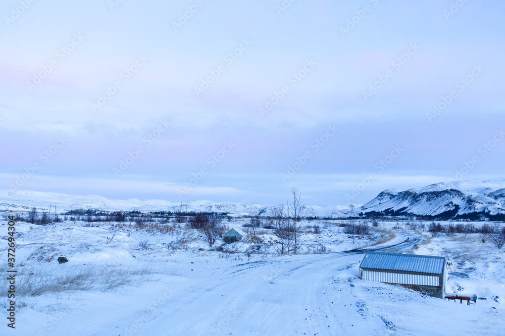 Natural winter landscape of a house in the middle of a snowy field in iceland