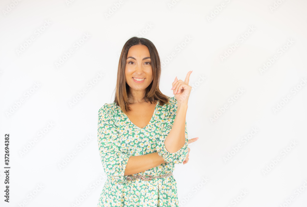 Beautiful woman in green dress pointing something smiling Beautiful woman in green dress pointing something smiling