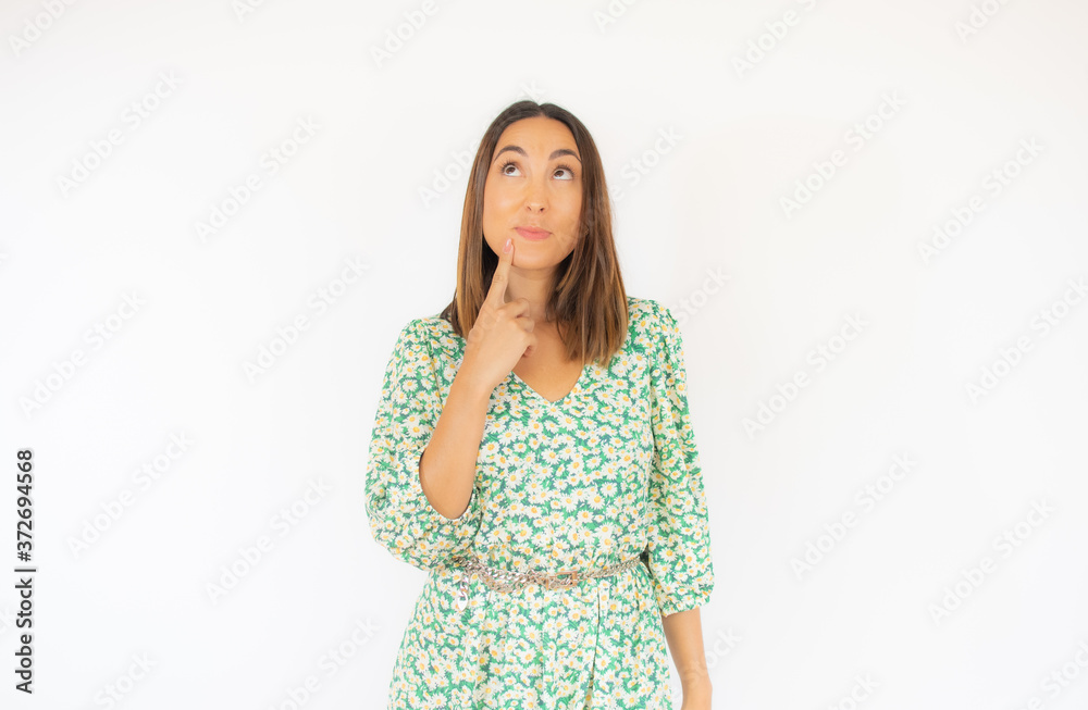 Beautiful woman in green dress with thoughtful gesture Beautiful woman in green dress with thoughtful gesture