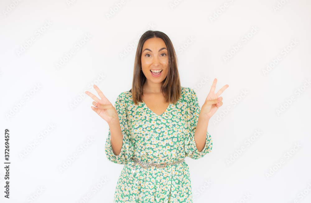 Beautiful woman in green dress with victory gesture smiling Beautiful woman in green dress with victory gesture smiling