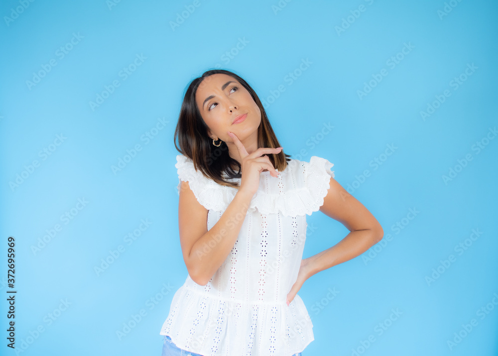 Pretty woman in white shirt with thoughtful gesture Pretty woman in white shirt with thoughtful gesture