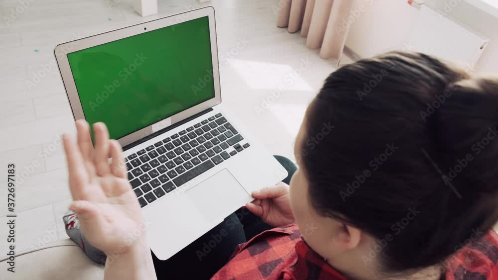 The girl communicates online with family and looks at the green screen. The girl communicates online with family and looks at the green screen.