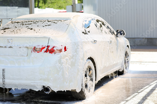Modern automobile in foam at car wash