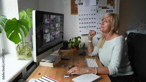 Smiling mature woman having video call via computer in the home office. Online team meeting video conference calling from home. Attractive Businesswoman Telework. Business video conferencing.