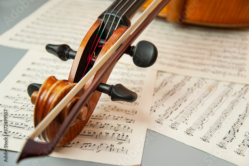 Fragment of a cello or violin with a bow on a background of notes and a place for text