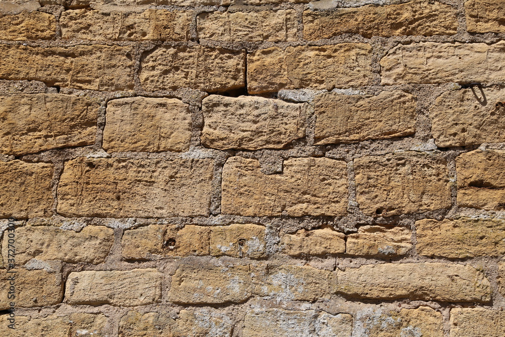 A closeup view of a textured Cotswold stone wall.