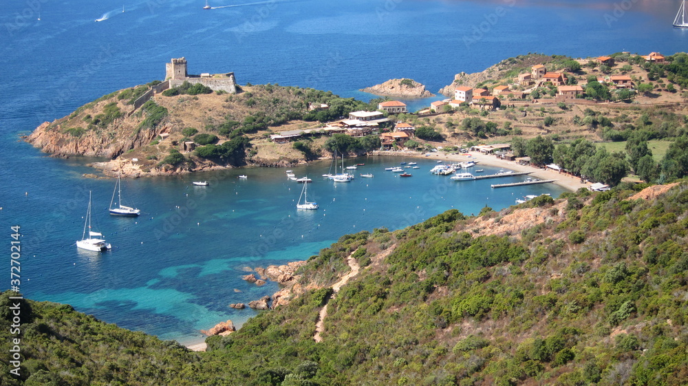 Malerische Bucht in der Calanche auf Korsika mit Strand und Booten 