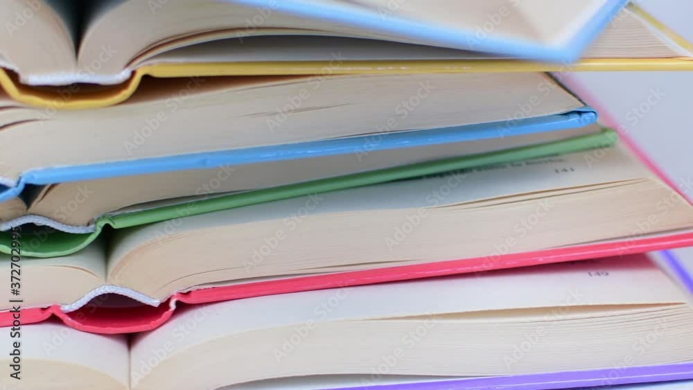 Desk with stack of open study books. Textbooks for the student, university. Study from home. Distance education concept. Desk with stack of open study books. Textbooks for the student, university. Study from home. Distance education concept.