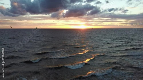 Dron Flying Over Sea in a Beautiful Sunset Kiteboarders Kiteserfing in the Backgroiund. Aerial Drone Shot. Sunrise Over the Sea. Colorful Sunset on the Baltic Sea, Latvia.