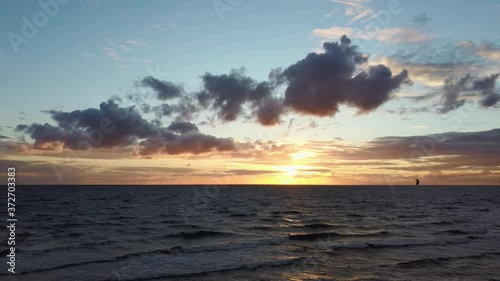 Dron Flying Over Sea in a Beautiful Sunset Kiteboarders Kiteserfing in the Backgroiund. Aerial Drone Shot. Sunrise Over the Sea. Colorful Sunset on the Baltic Sea, Latvia.
