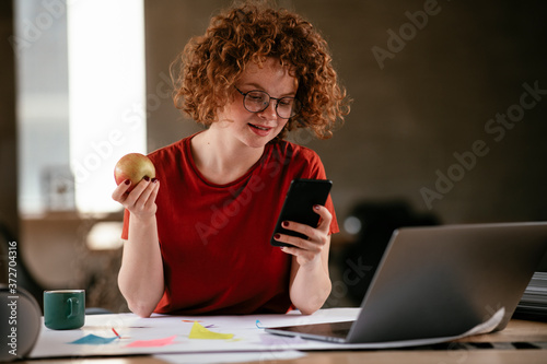 Beautiful businesswoman working in the office. Young woman using the phone.