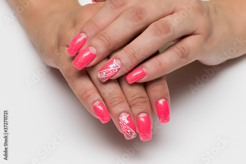 coral moon manicure on long square nails close-up on a white background with crystals and white abstraction 
