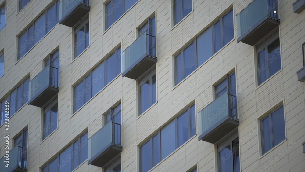 Close up shot of residential building. Close up Of An Apartment Blocks. The building features exterior with small balconies Close up shot of residential building. Close up Of An Apartment Blocks. The building features exterior with small balconies