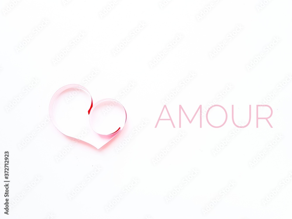 The heart is made of red paper on a white background. The text is love in French. Valentine's Day.