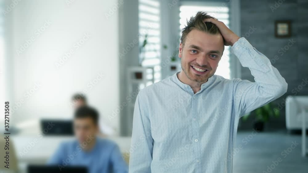 Confident happy office worker looking at camera in modern office, positive male employee with smiling face satisfied with good job career, close up portrait in slow motion Confident happy office worker looking at camera in modern office, positive male employee with smiling face satisfied with good job career, close up portrait in slow motion