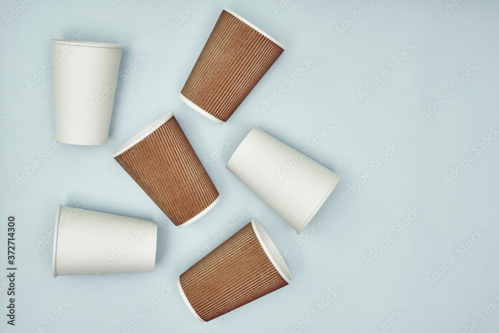 Paper cup in hand on a colored background. Eco-friendly materials in a ...