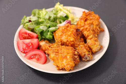 fried crispy chicken leg with salad and tomato