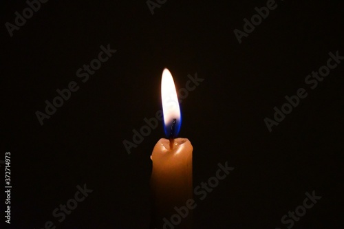 White Candles Burning in the Dark with lights glow, the burning candle's flame in the dark background, a symbol of the Christian faith, Candles burning in the Dark with lights glow