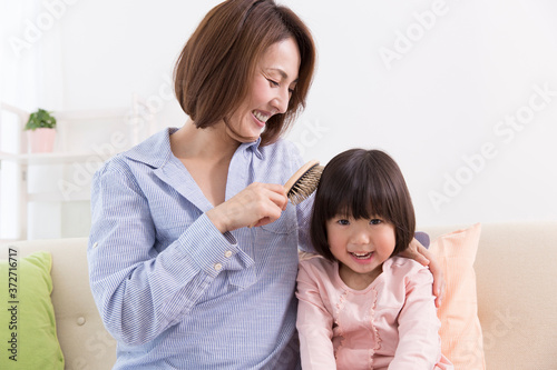 娘の髪を梳かす母