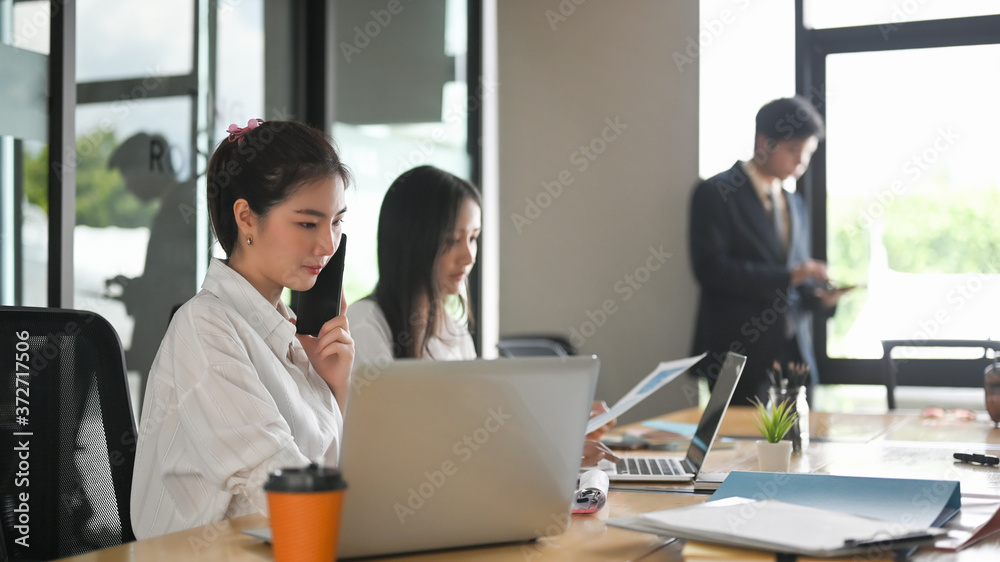 A comfortable business workspace is surrounding by a happy employee and various office stuff. A comfortable business workspace is surrounding by a happy employee and various office stuff.