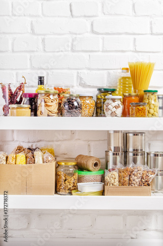 Foto Set of long storage term foods on pantry shelf prepared for disaster emergency c