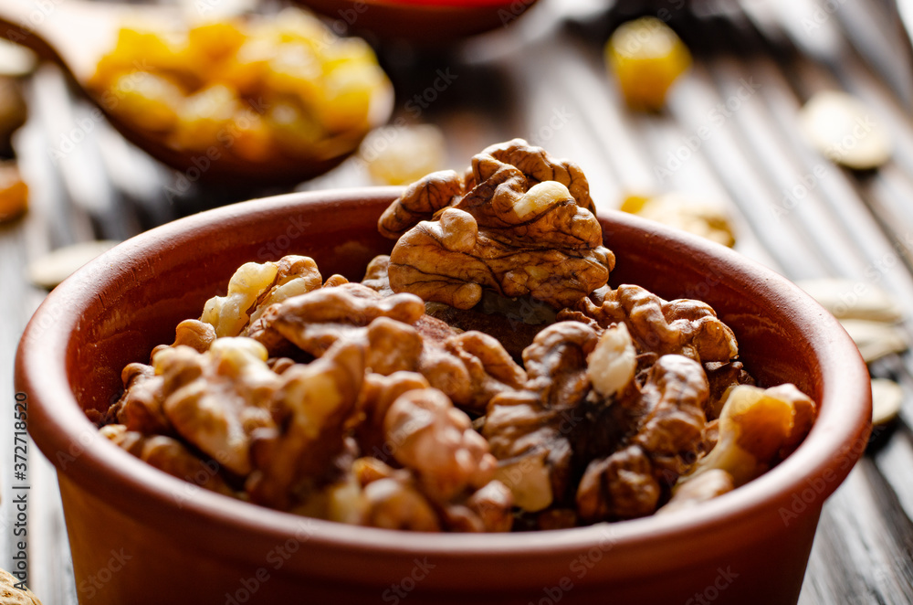 Walnuts in clay bowl on kitchen wooden table food background Walnuts in clay bowl on kitchen wooden table food background