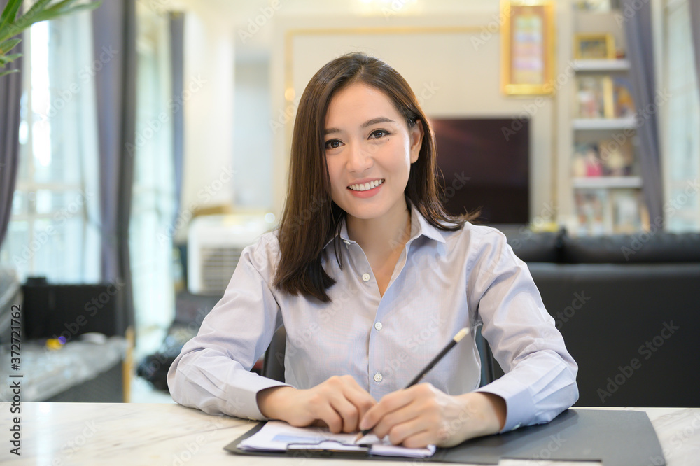 Headshot screen view of young Asian businesswoman is online using Video conference with partners or business coworkers from her home . Headshot screen view of young Asian businesswoman is online using Video conference with partners or business coworkers from her home .